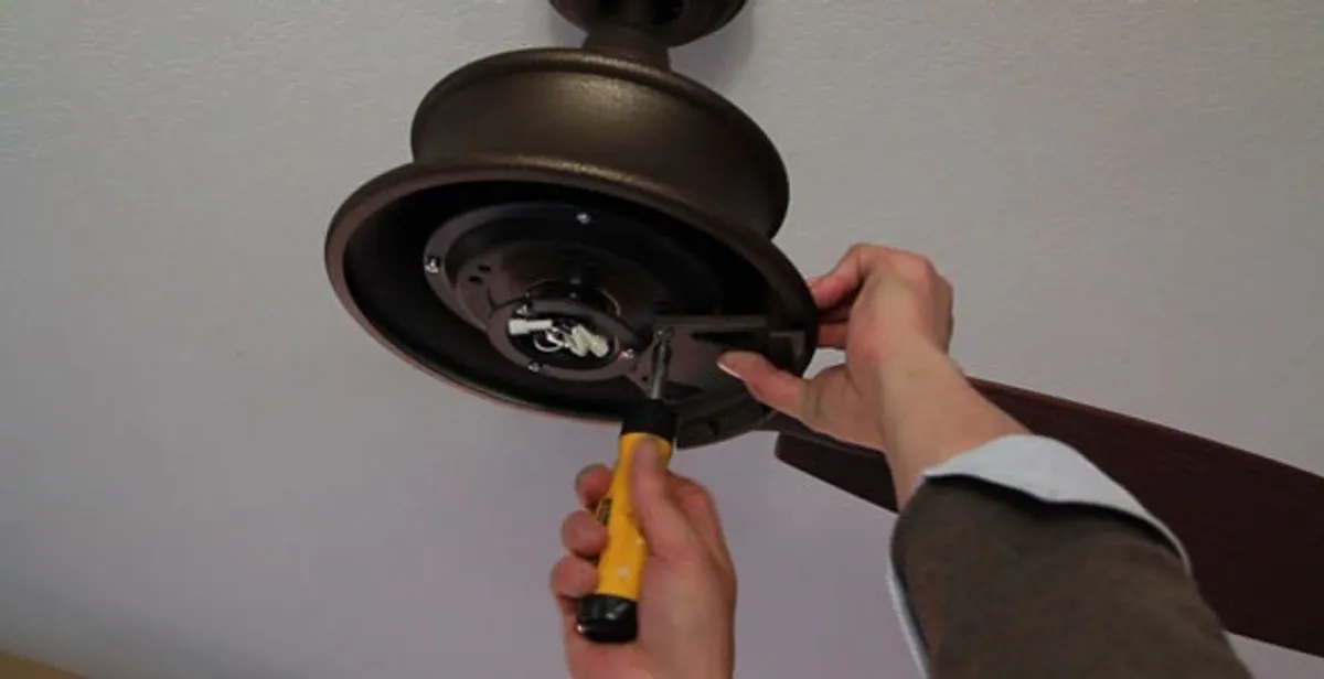 Electrician installing ceiling fan mounting bracket and fixture in Clearwater, FL