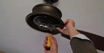 Electrician installing ceiling fan mounting bracket and fixture in Clearwater, FL