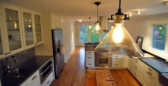 Residential electrician installing modern indoor light fixture in a home in Clearwater, FL